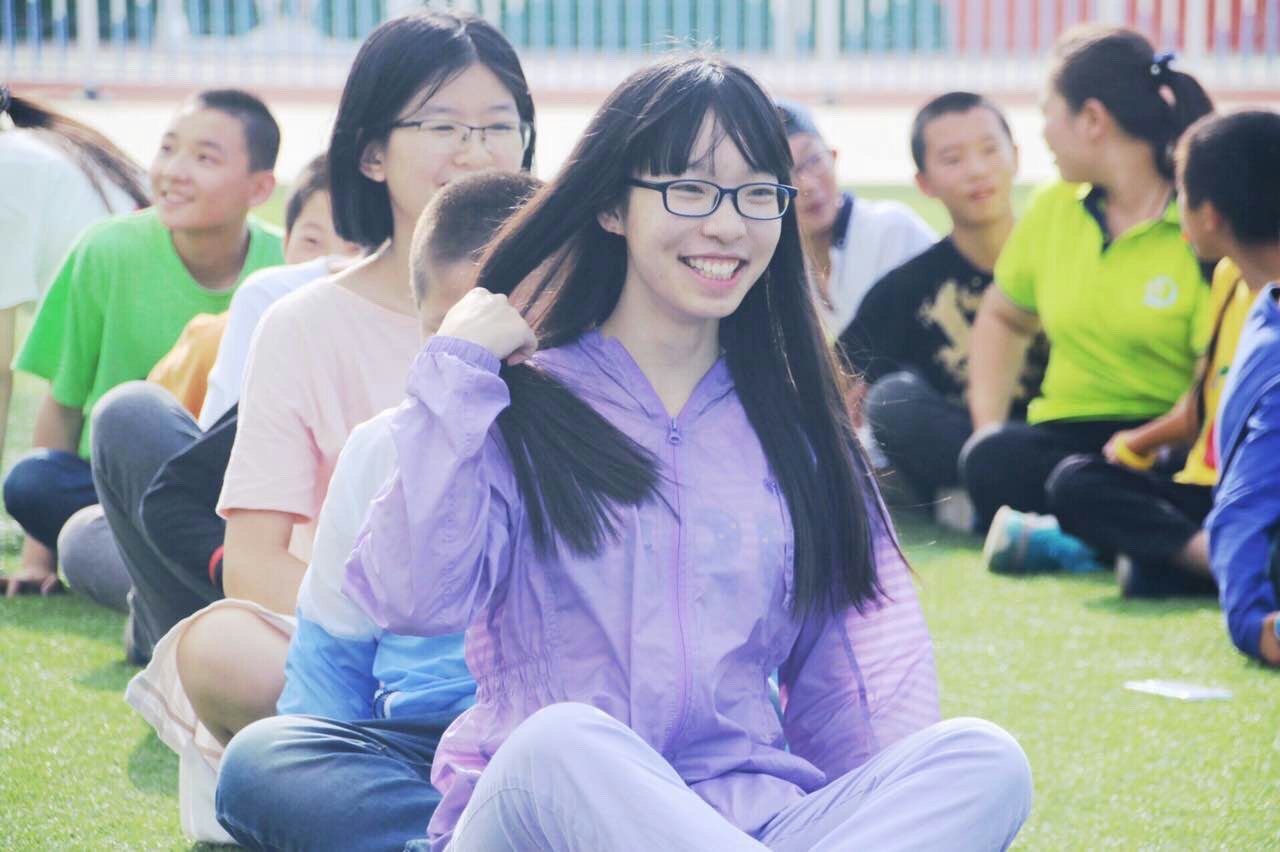Jiawen Wu smiling while seated with a group during her volunteer teaching experience in Gansu, China, in 2018.